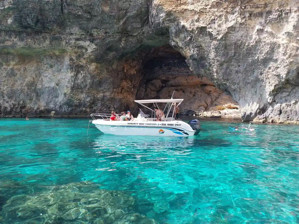 A boat at a cave mouth in the cliff