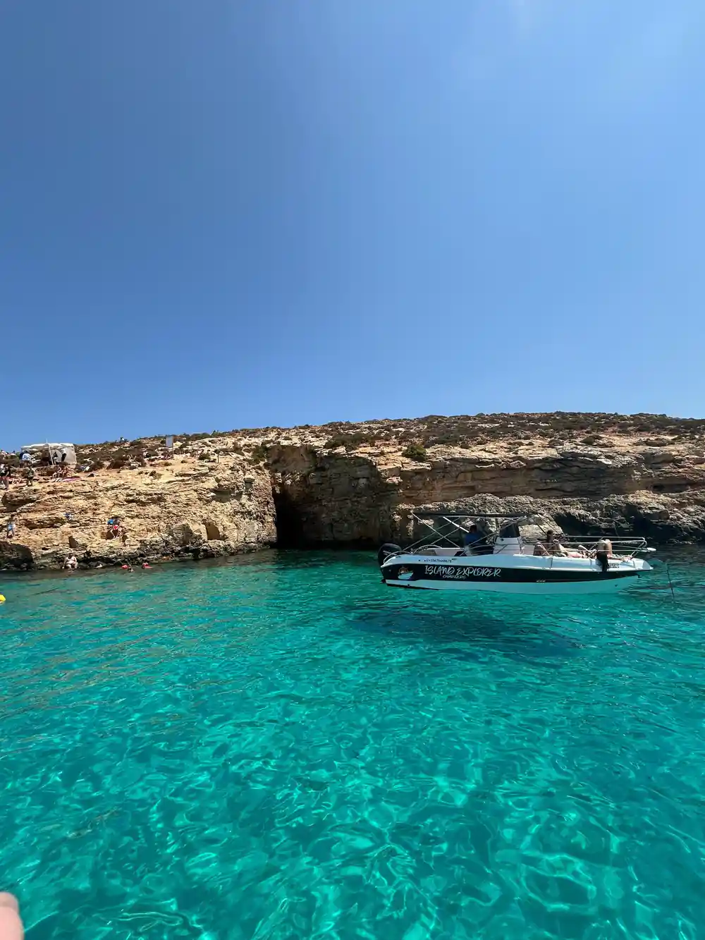 A boat moored by the rocks in turquoise water