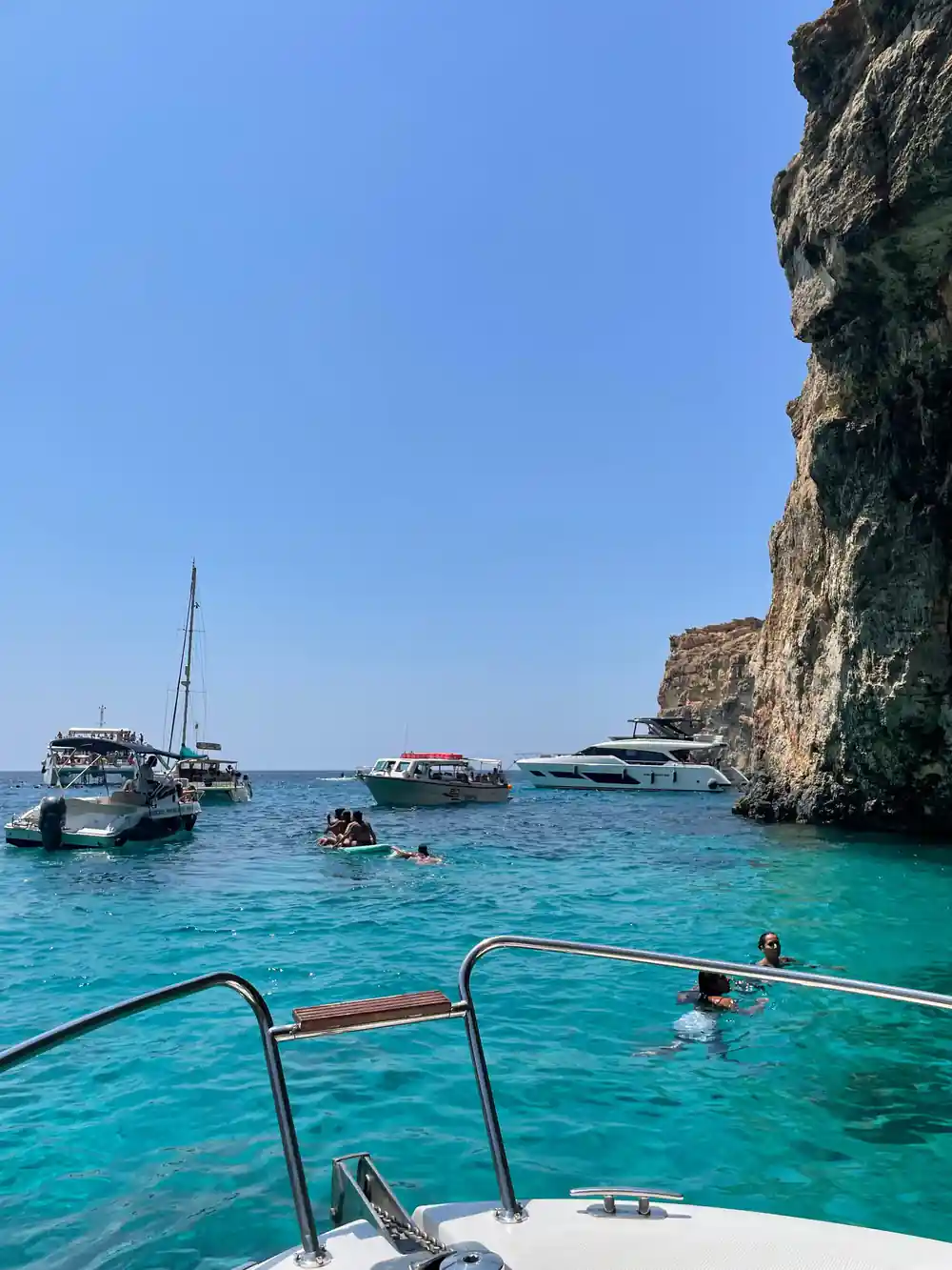 Boats and swimmers in the channel from aboard