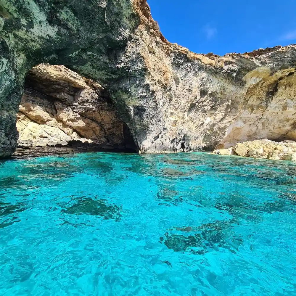 Clear turquoise water over rock and weed