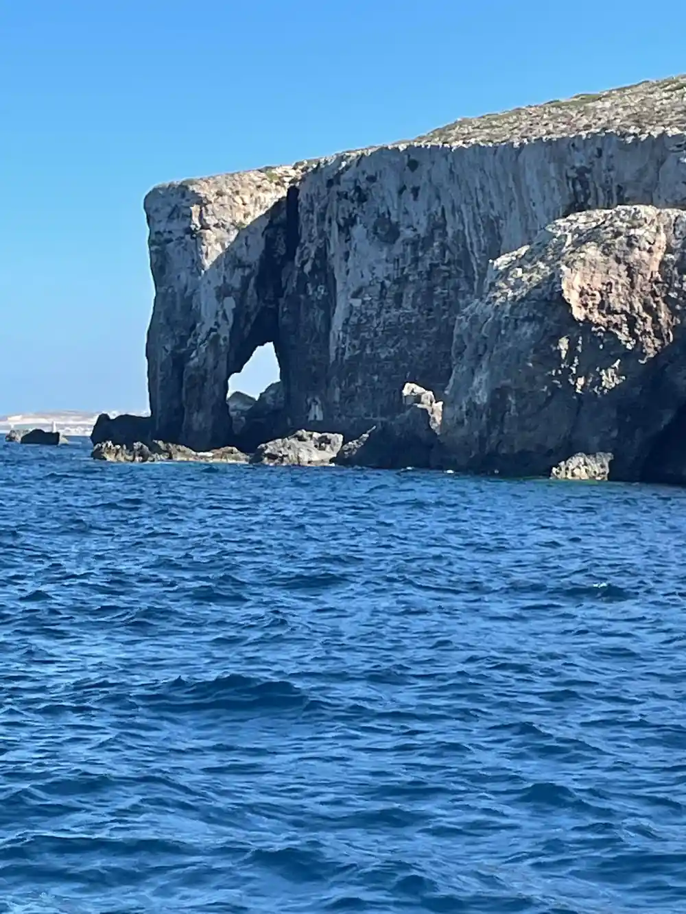 A large rock stack with an arch through it