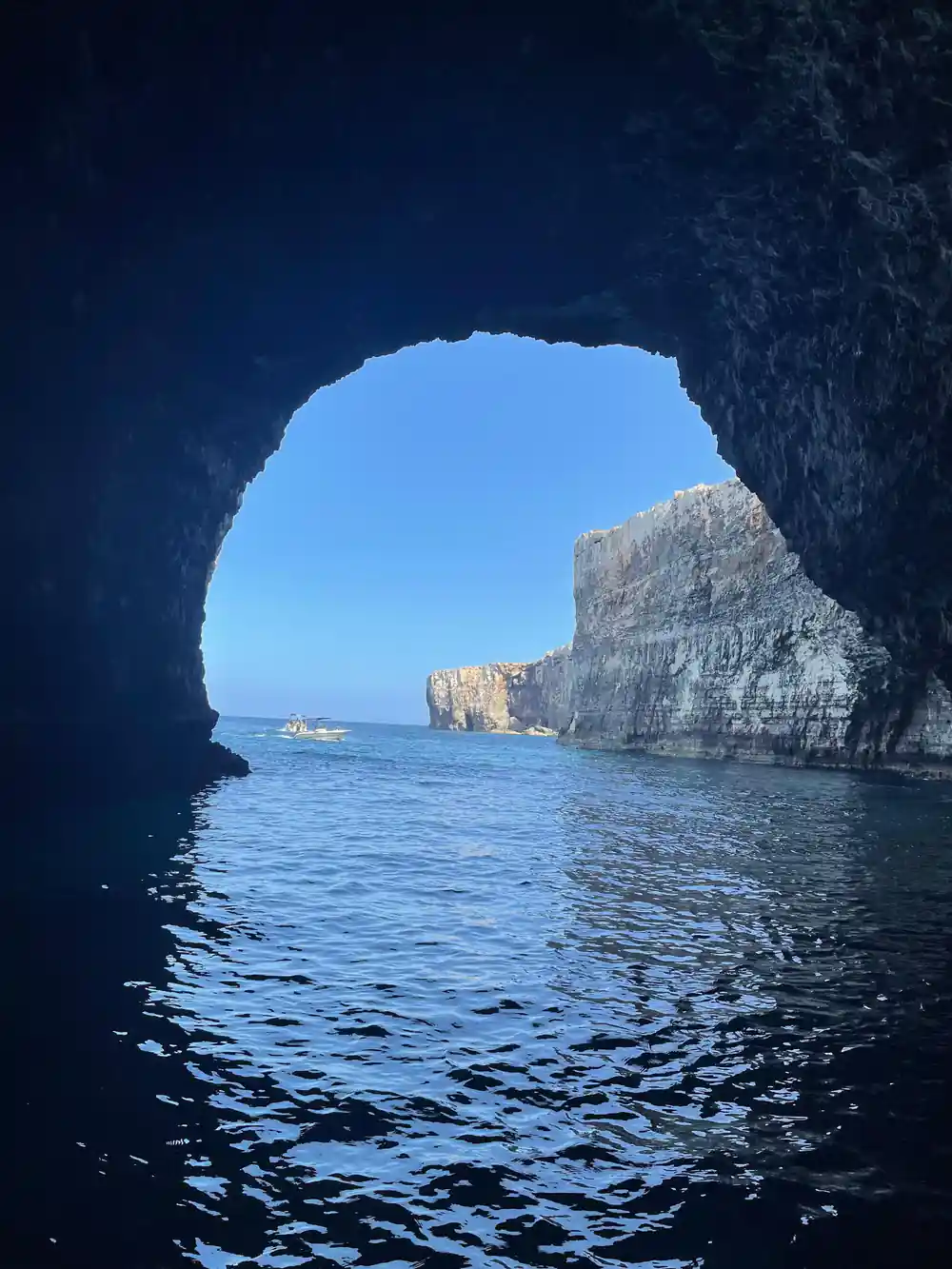 Looking out of a cave arch to a rock stack