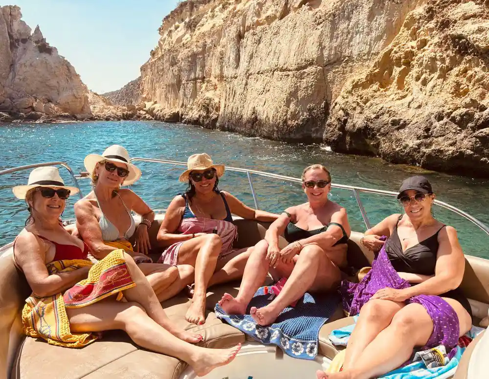 Passengers seated on the bow below a cliff