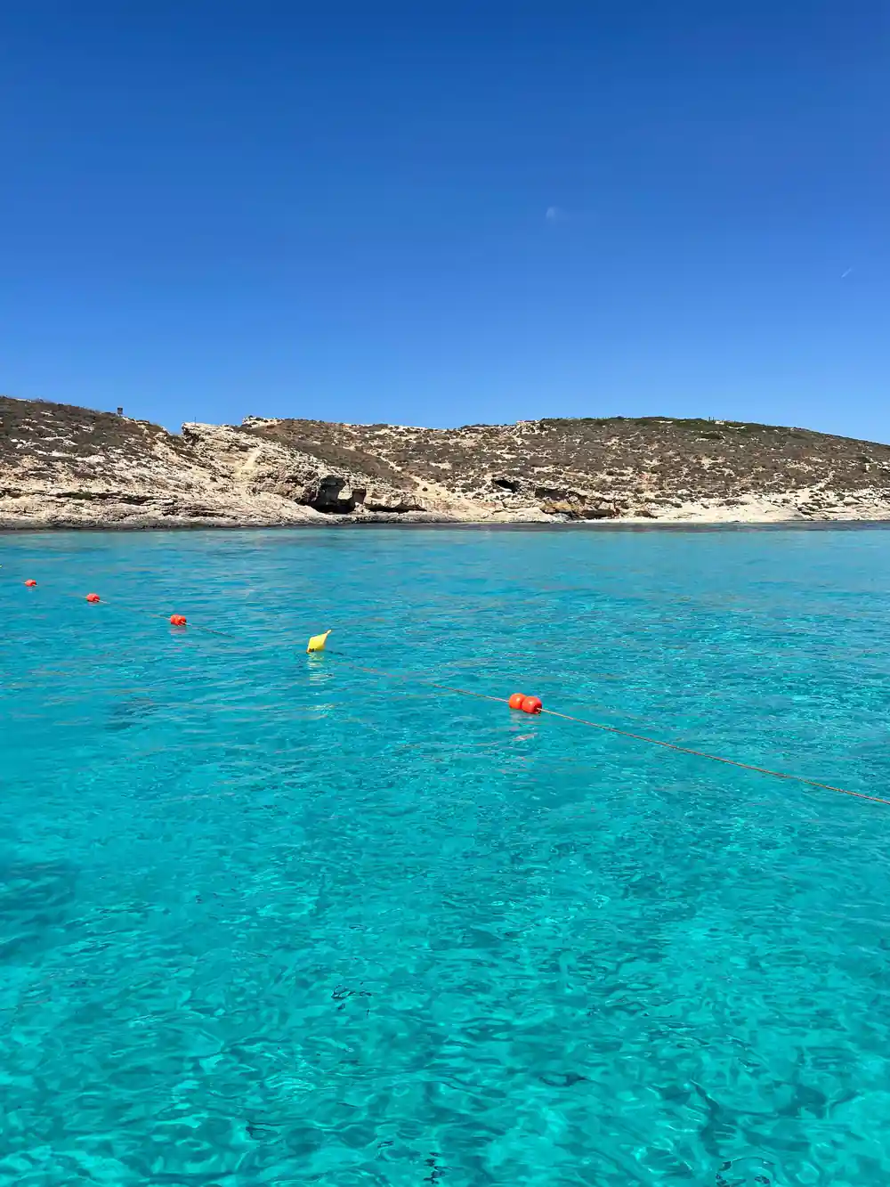 The rocky shore of the lagoon with buoys