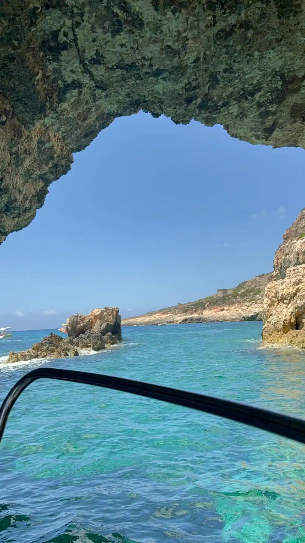 A rocky shore and open sea past the windscreen