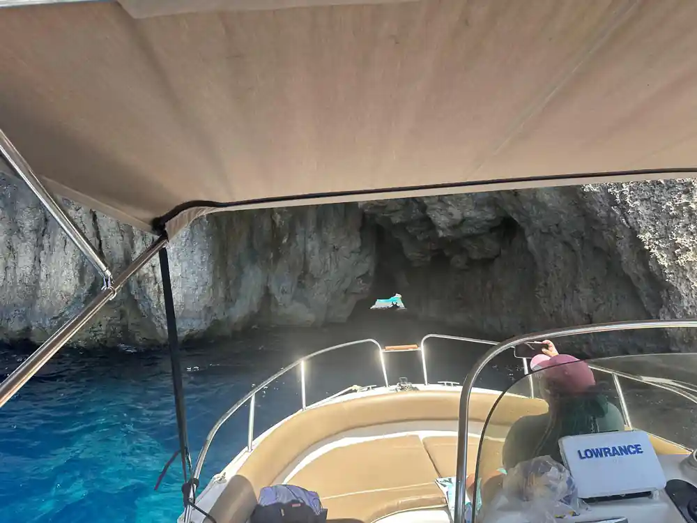 The skipper at the wheel under the boat's canopy