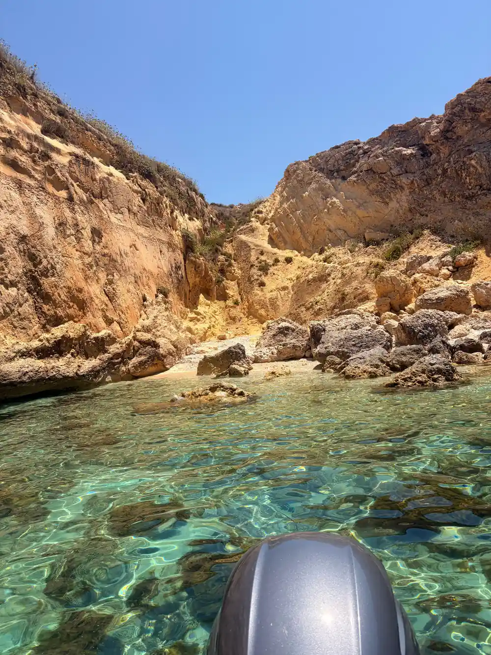 A small rocky beach at the foot of a cliff
