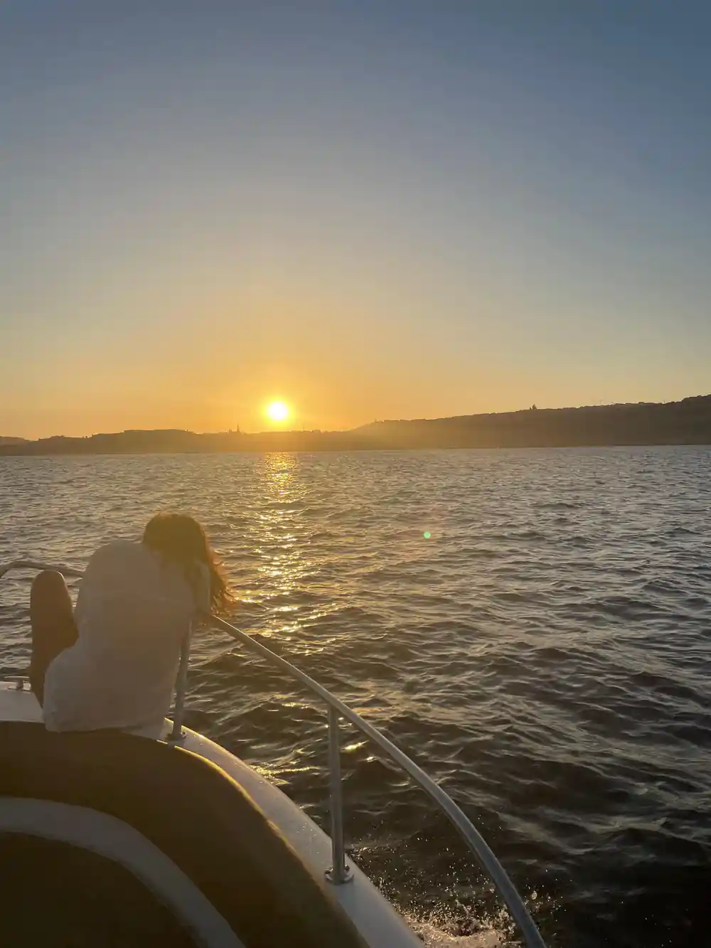 Sunset over the sea from the boat's stern
