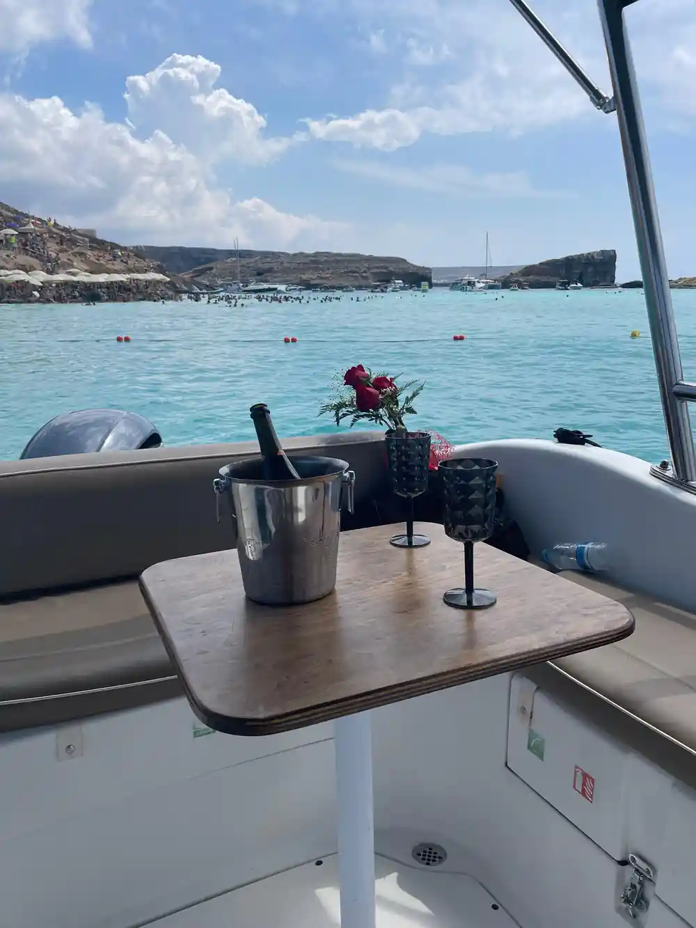 A table set on the boat's deck with an ice bucket