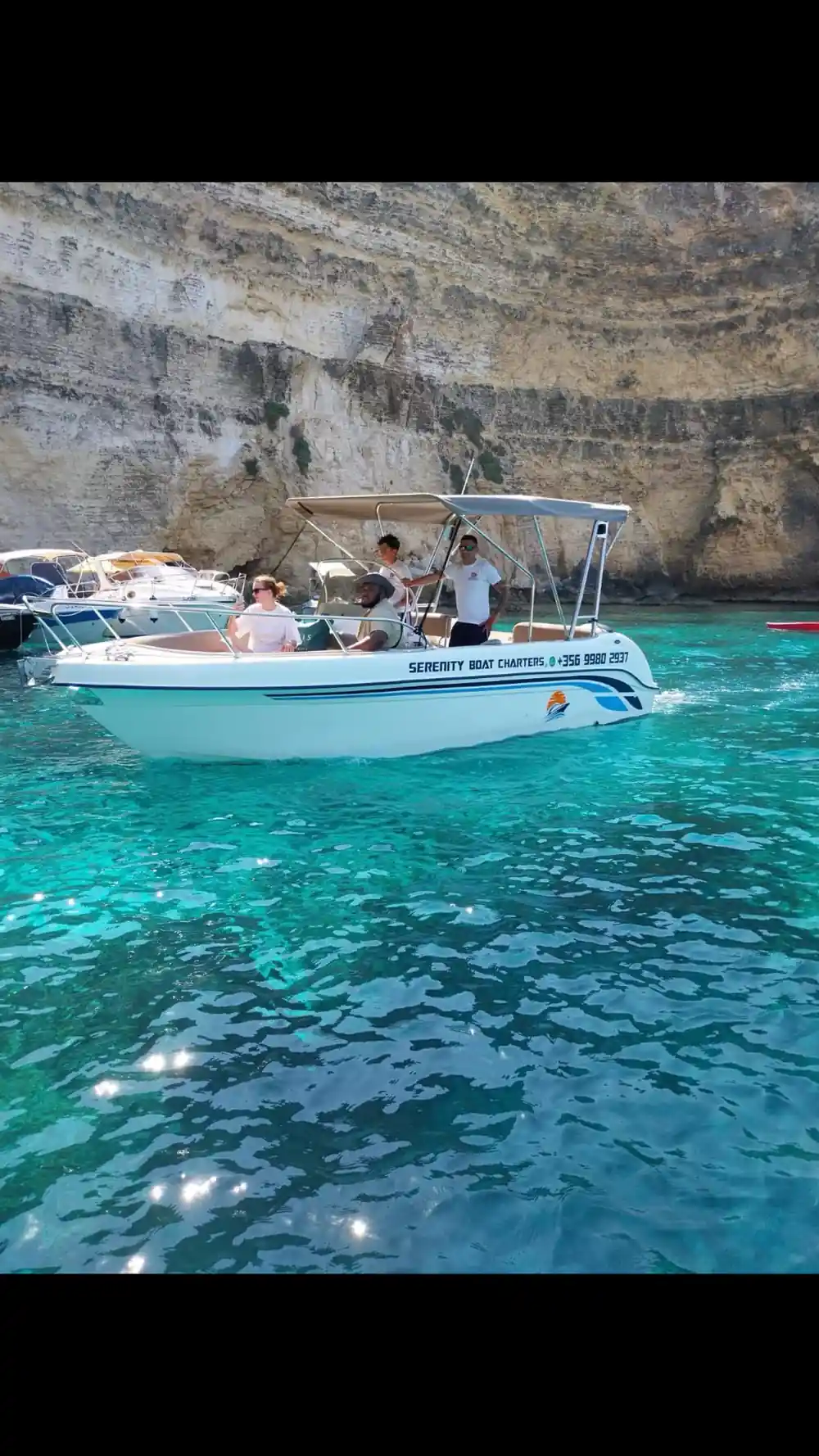 Two boats moored under the cliff